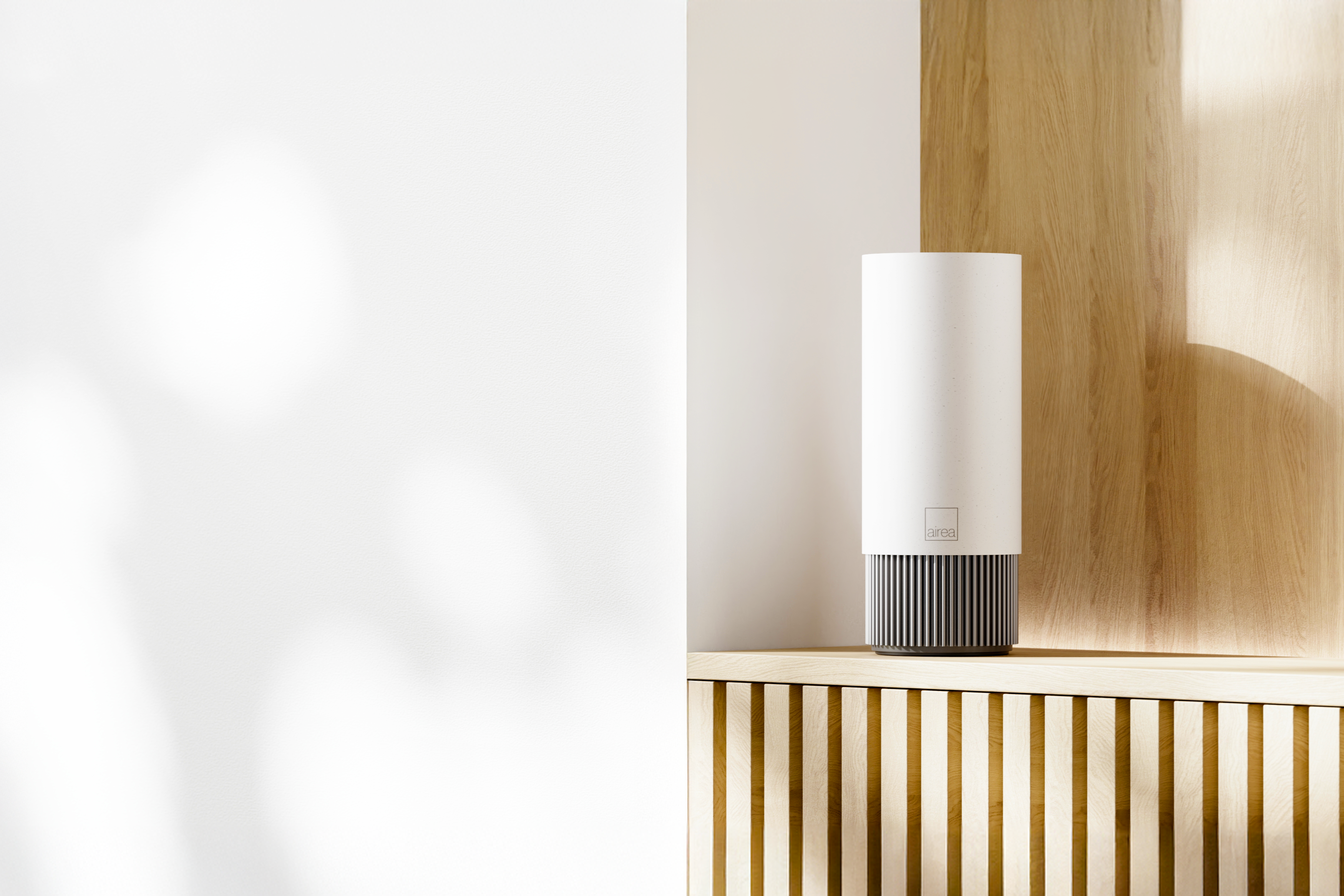 A compact Airea Space Purifier sits on a minimal wood shelf, continuously protecting the space from airborne and surface contaminants.