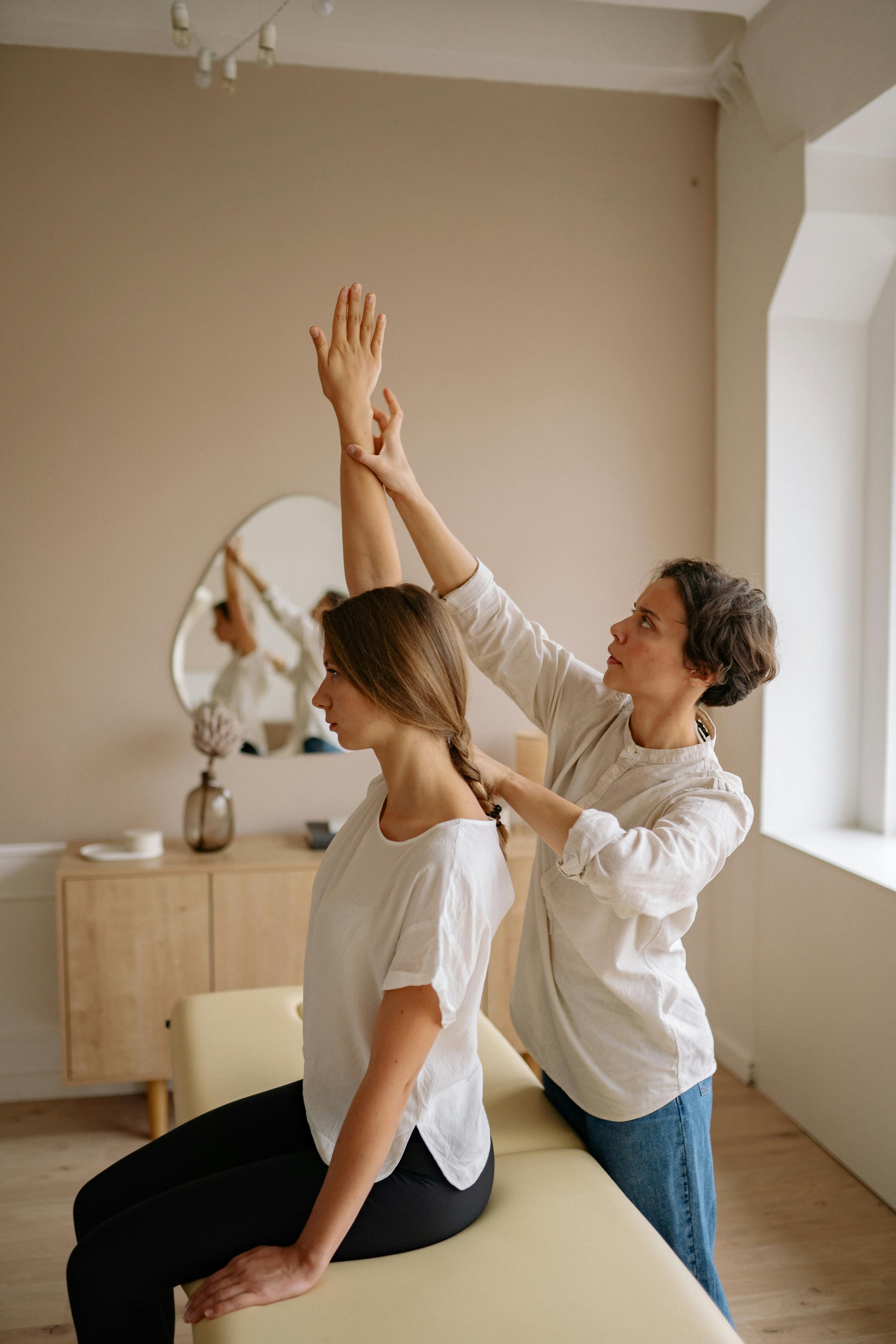 An alternative medicine practitioner helping a patient stretch.
