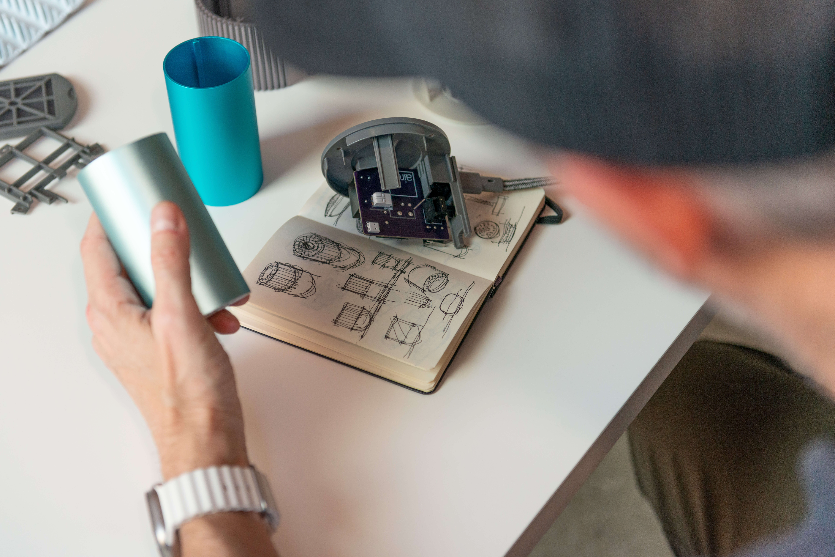 Scott Wilson, founder of Airea Wellness, sketching designs for the Airea Space Purifier in a notebook.