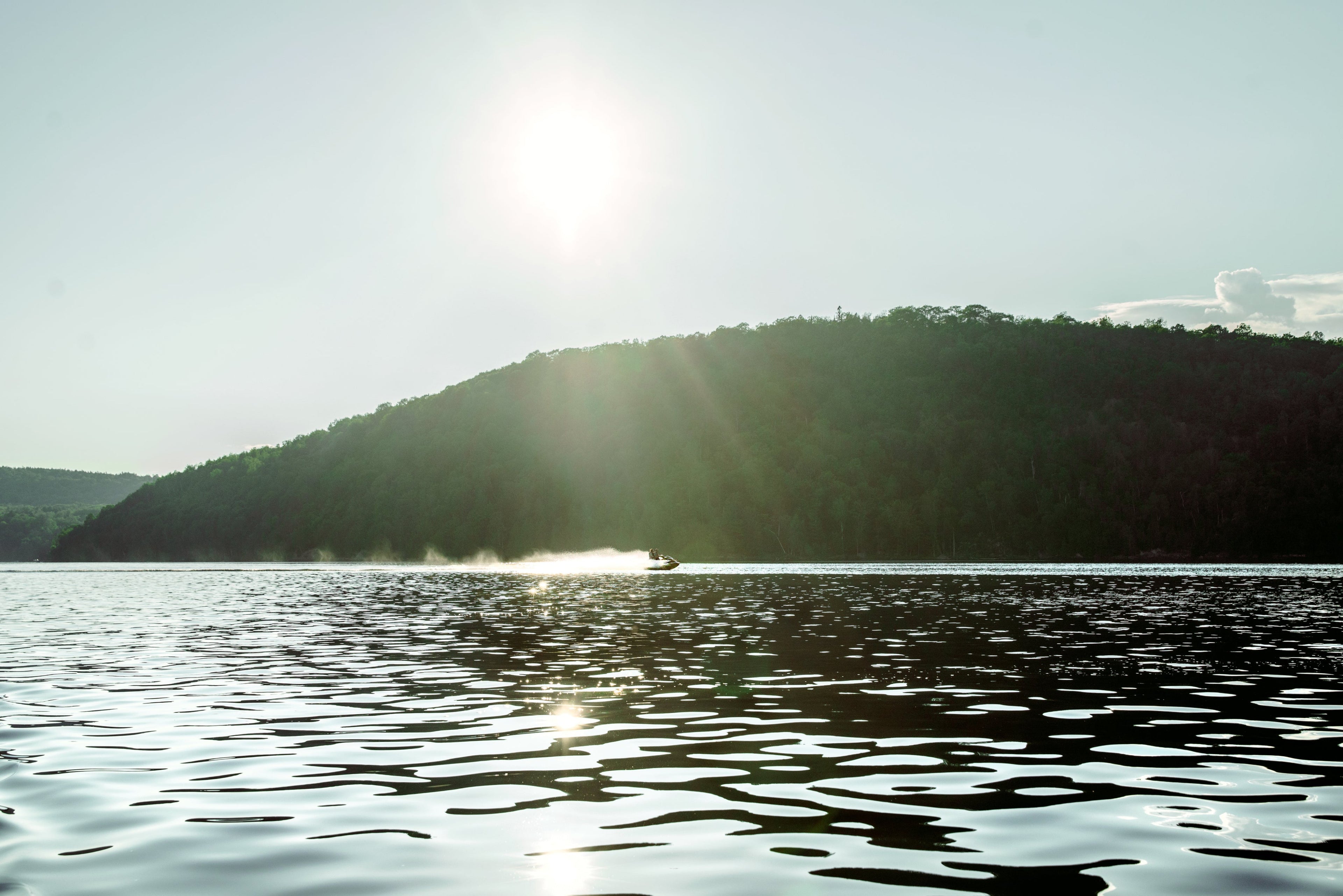 Sparkling sunlight hitting calm lake.